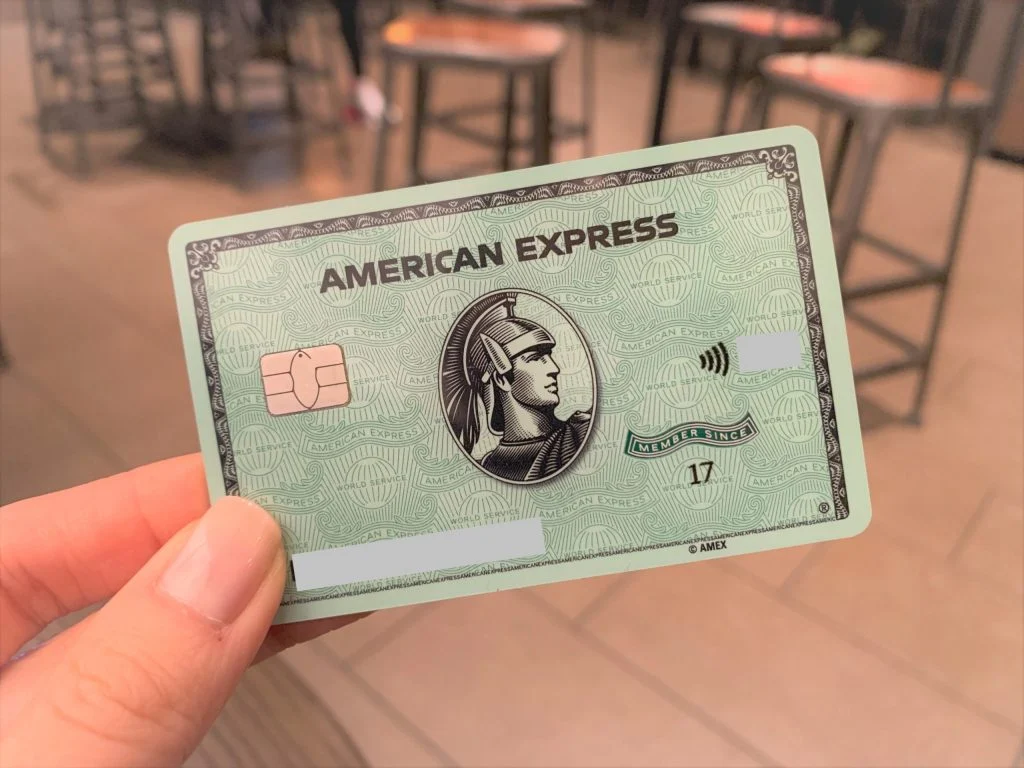 uma mao segurando o cartao American Express Green
