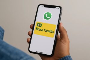Início 16 Imagem mostrando uma mão segurando um smartphone cuja tela exibe os logotipos do WhatsApp e do programa Bolsa Família. A interface do aparelho está clara e nítida, destacando o ícone verde do WhatsApp na parte superior e o cartão amarelo do Bolsa Família com a bandeira do Brasil no canto esquerdo. A cena sugere comunicação ou consulta de informações pelo aplicativo, remetendo ao tema Empréstimo Bolsa Família pelo WhatsApp.
